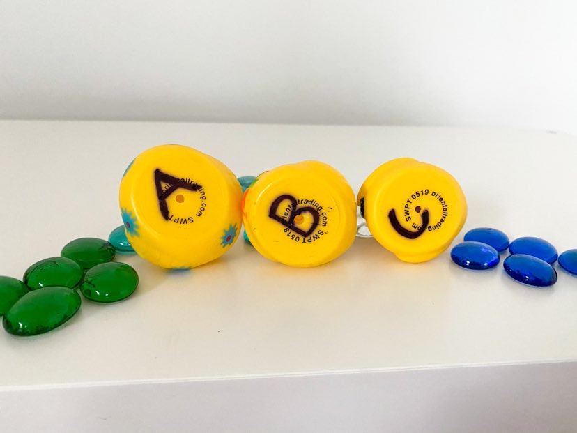 pebbles with rubber ducks on their sides emphasizing letters on the bottom 