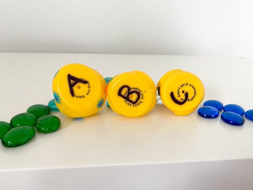pebbles with rubber ducks on their sides emphasizing letters on the bottom 
