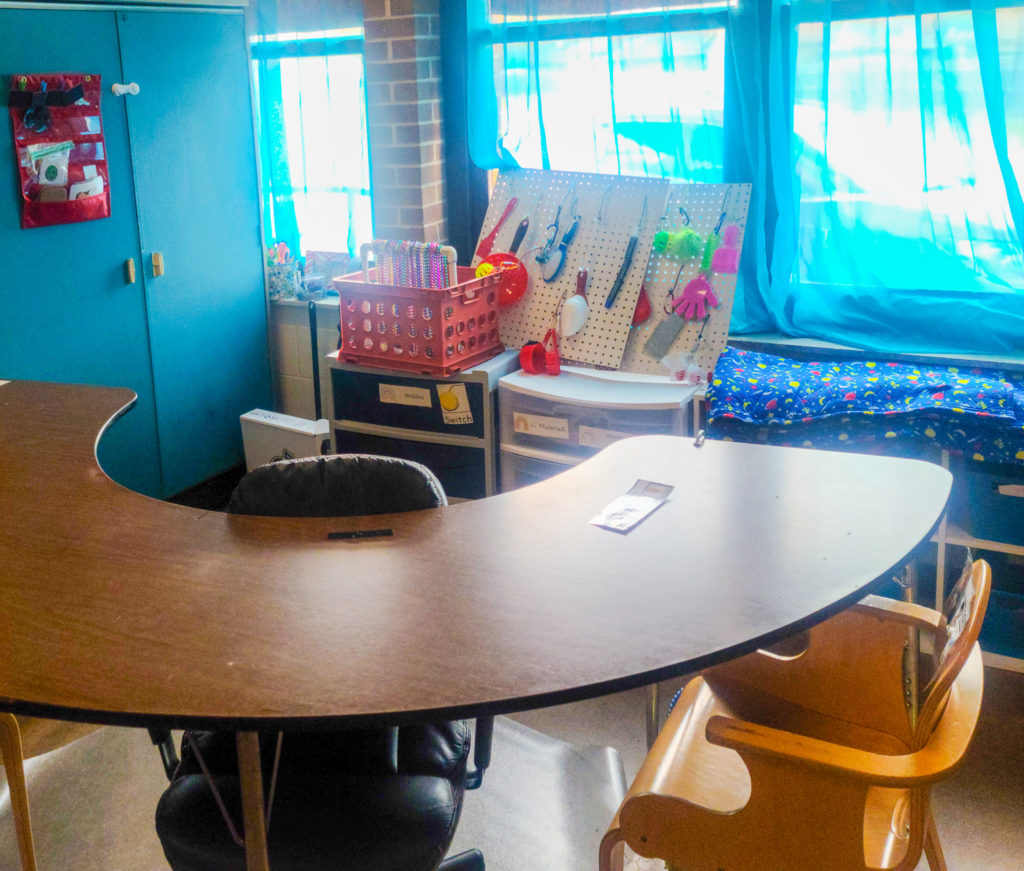 Picture of u-table with a white shelf behind it.