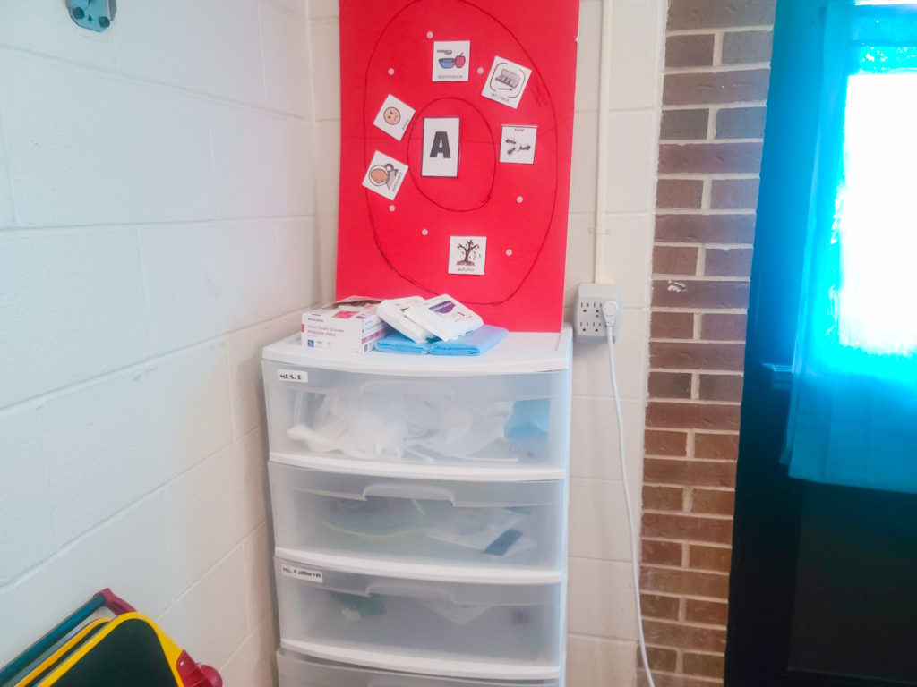 Plastic drawers with a red circle chard on top.