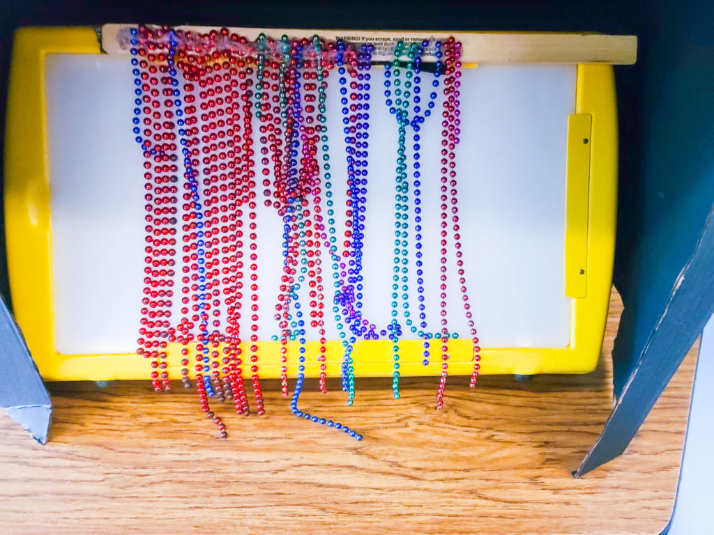 A large yellow light box with a bead curtain over the front.
