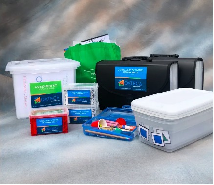 Image of the full OATECA kit showing the assessment box, rectangle containers, and the activities.