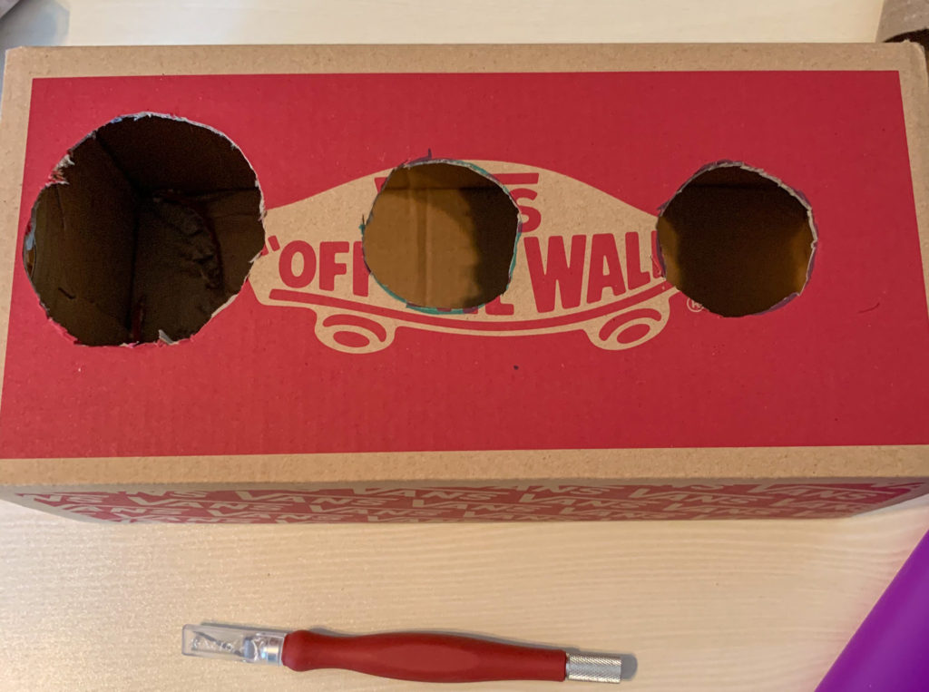 Cutting holes out of a box to make a task box.