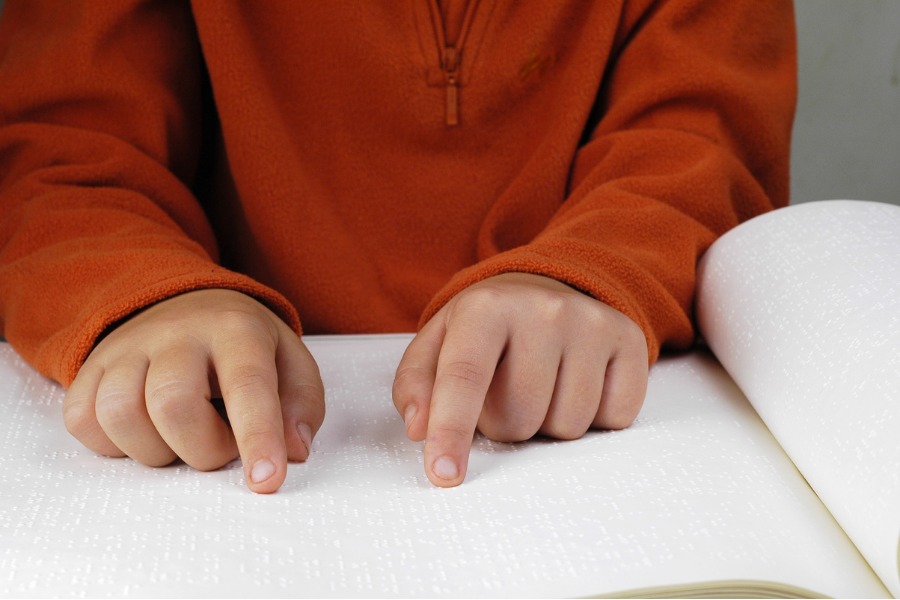 Visually impaired student reading braille.