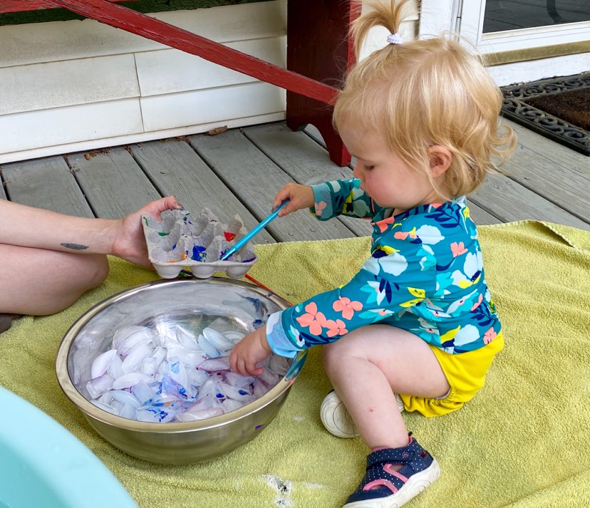 Little girl with paint brush painting icecubes 