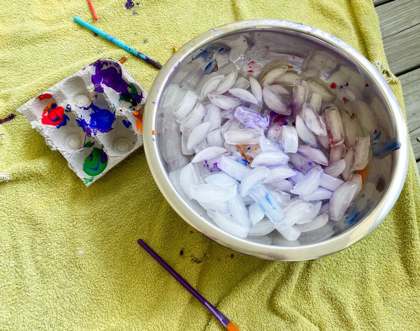 Painted icecubes with a tray of paint to the right 