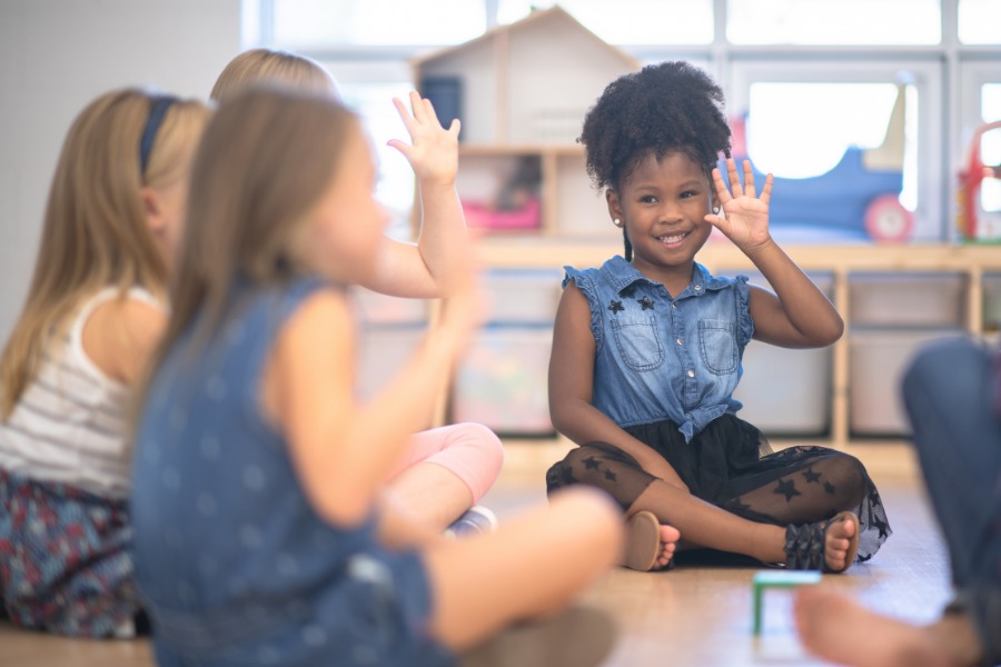 This is a photo of children greeting each other at a morning meeting group.
