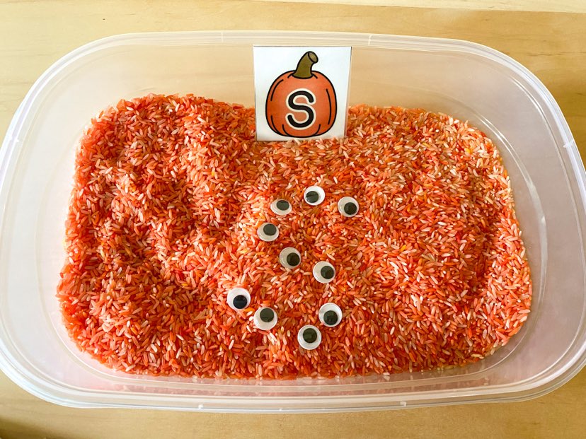 orange rice with a pumpkin featuring an uppercase S. google eyes placed to make formation pattern 
