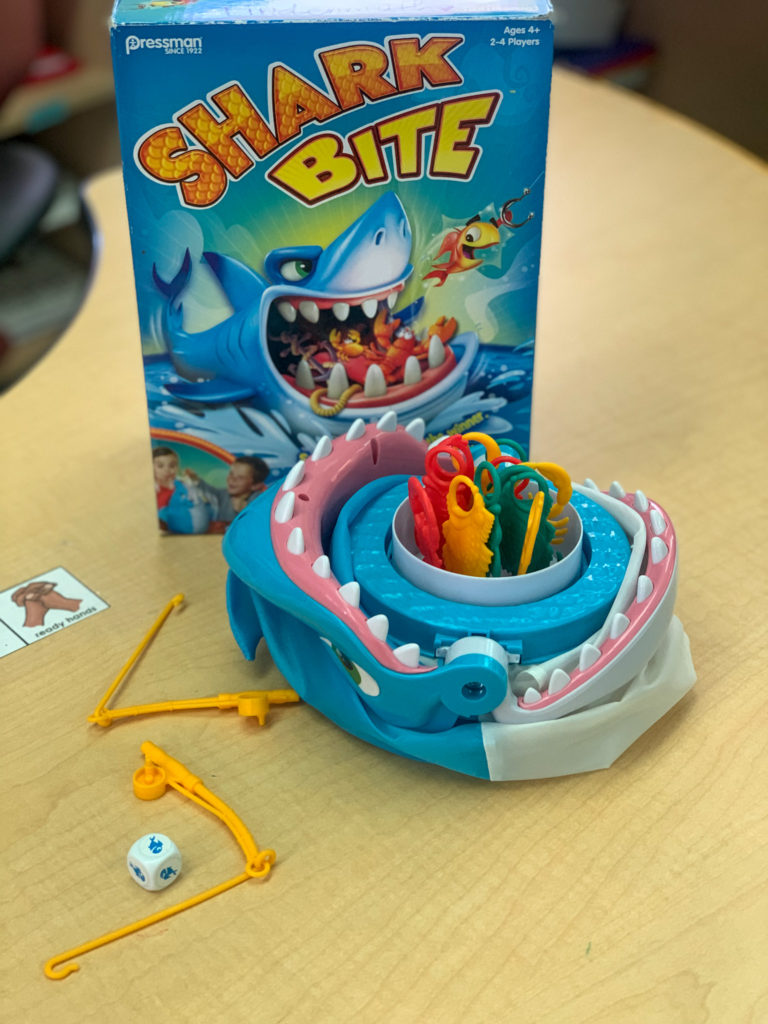 This is a photo of the game Shark Bite. There are fishing poles, sea creatures, a shark, and dice.