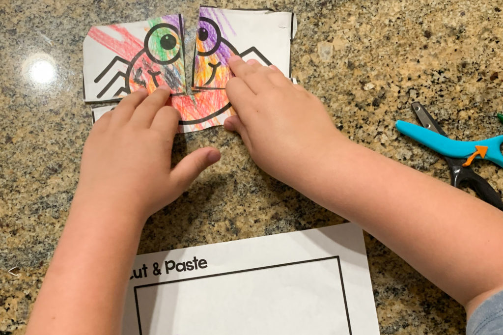 This is a photo go a child piecing together their picture after cutting it out.