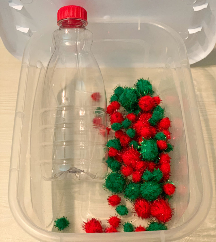 This is a photo of an errorless Christmas task box.  It is an empty coffee creamer bottle and some pom pom balls in a clear container.
