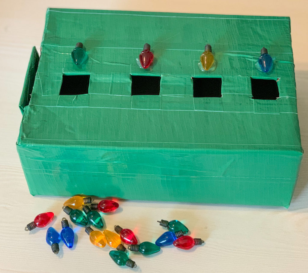 This Christmas task box is made with light bulbs. Students must place the correct color light bulb into a square hole with the same color light bulb.