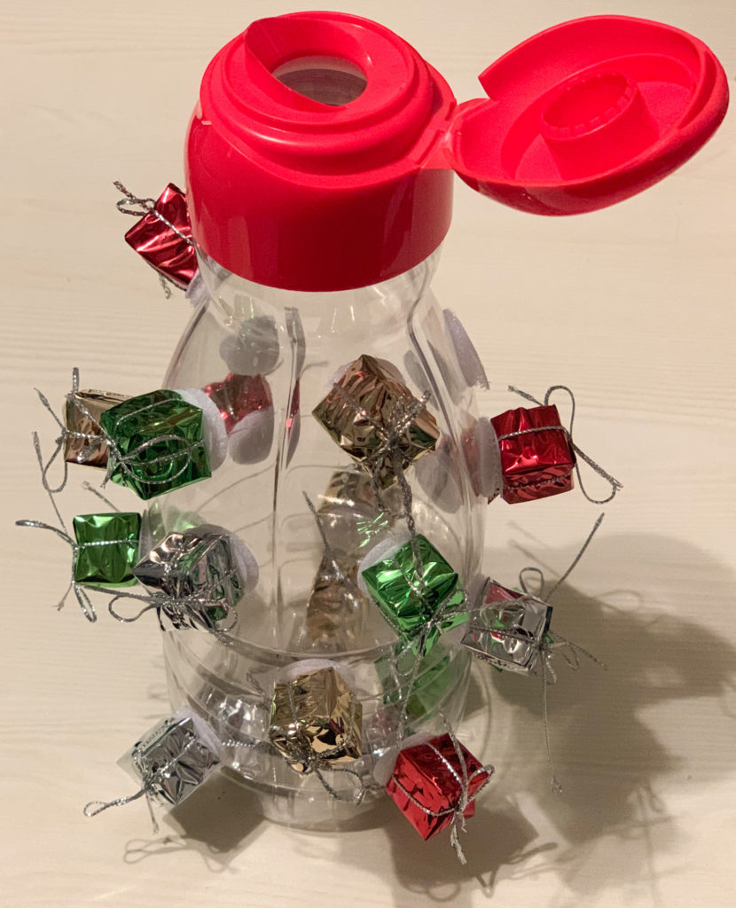 This is an errorless Christmas task box.  It is an empty coffee creamer bottle with mini presents velcroed to the sides.  Students have to hold the bottle, pull a present off, and stick it in the bottle. 