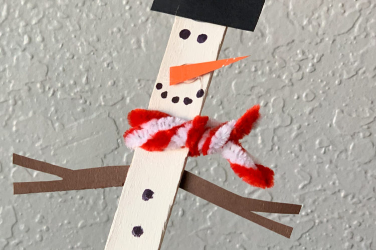 This is a snowman made out of a craft stick painted white, some construction paper, and a pipe cleaner.
