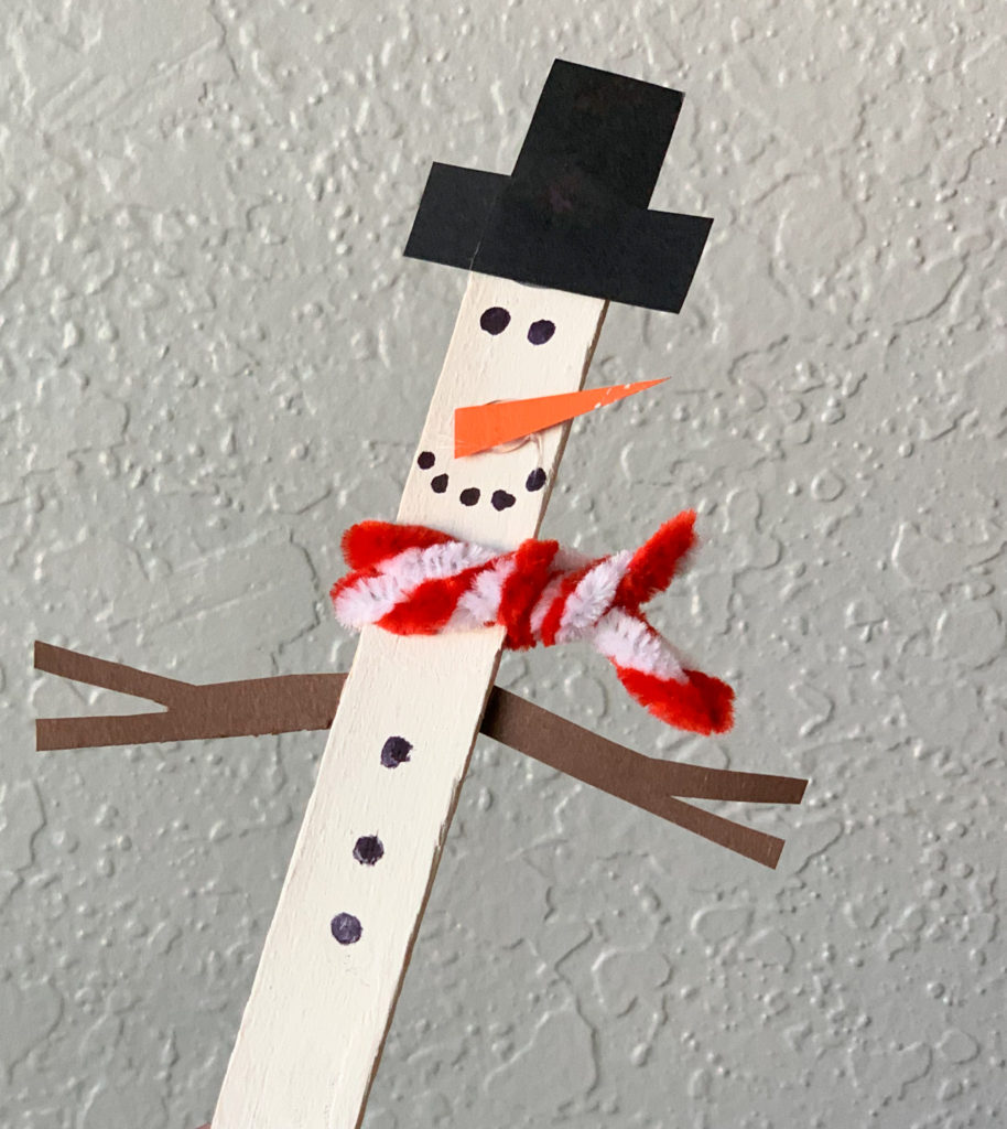 This is a snowman made out of a craft stick painted white, some construction paper, and a pipe cleaner.