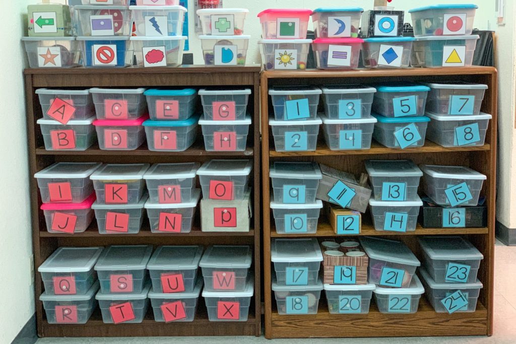 This is a photo of labeled task boxes on two shelves.