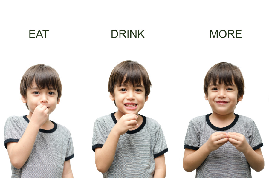 This is an image of a boy using baby sign language for eat, drink, and more