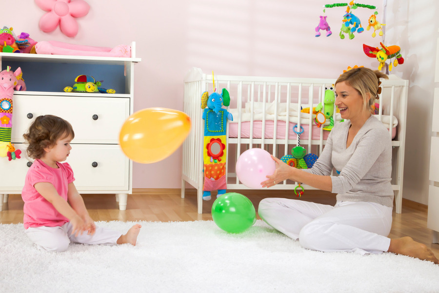 This is an image of a mother and toddler daughter playing catch with balloons.