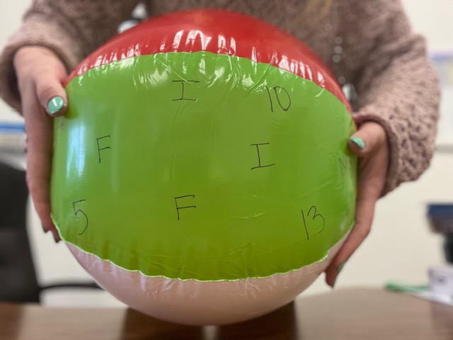 Beach ball with letters and numbers written on it.