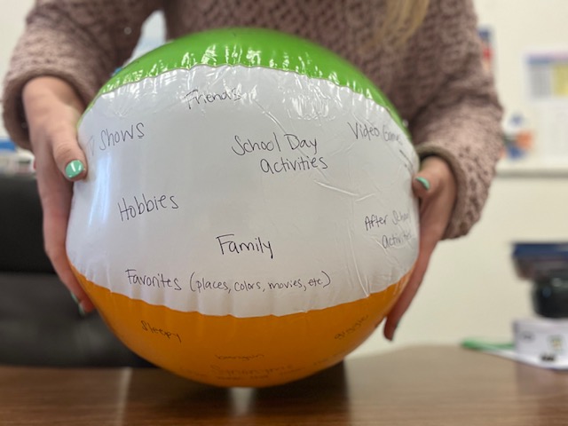 Beach ball with conversational topics written on it.