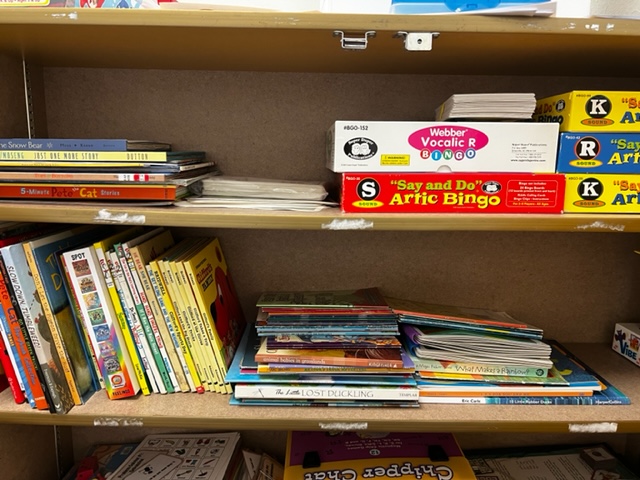 This is an image of books and games on a bookshelf.