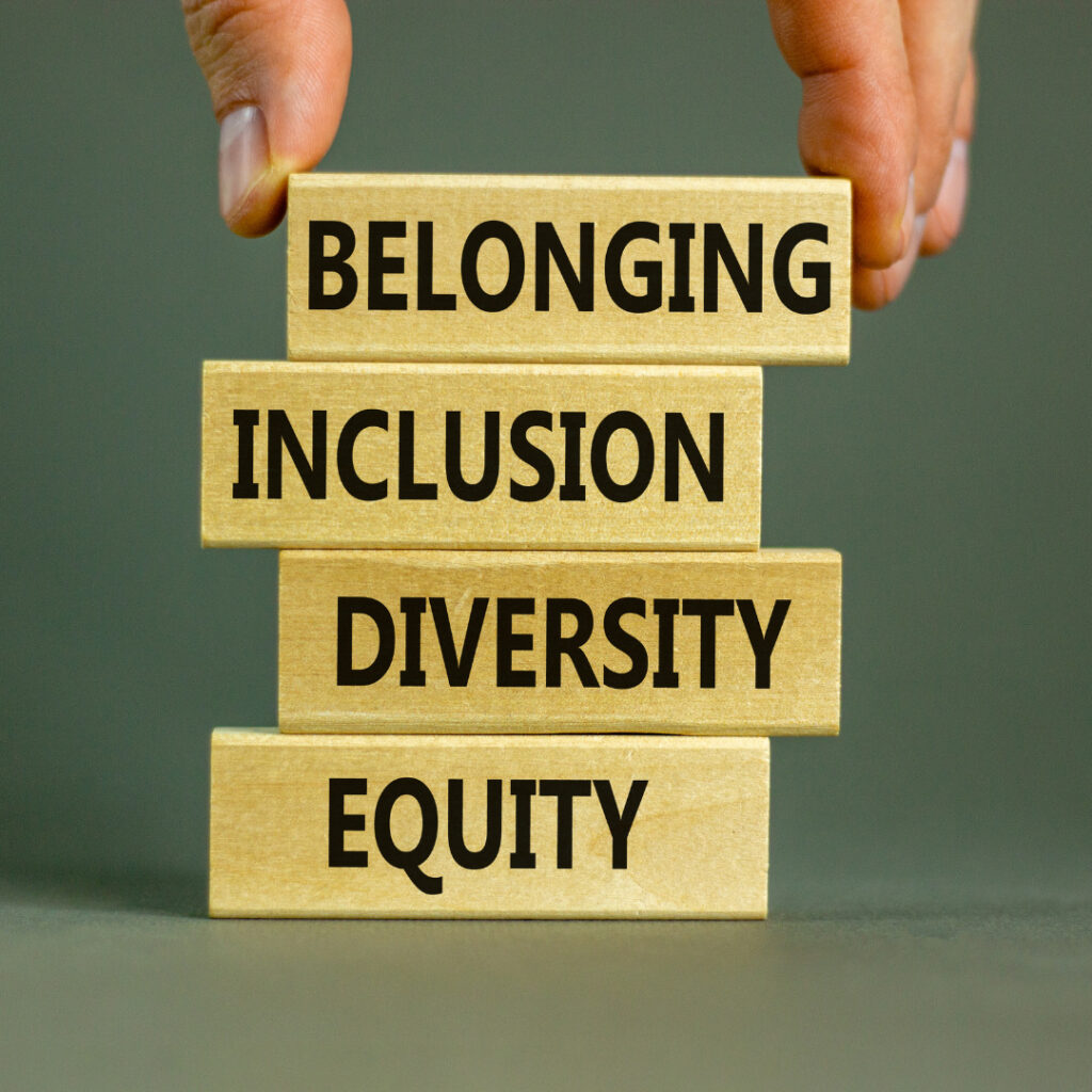blocks stacked on top of each other each with a word on them. From bottom: equity, diversity, inclusion, belonging