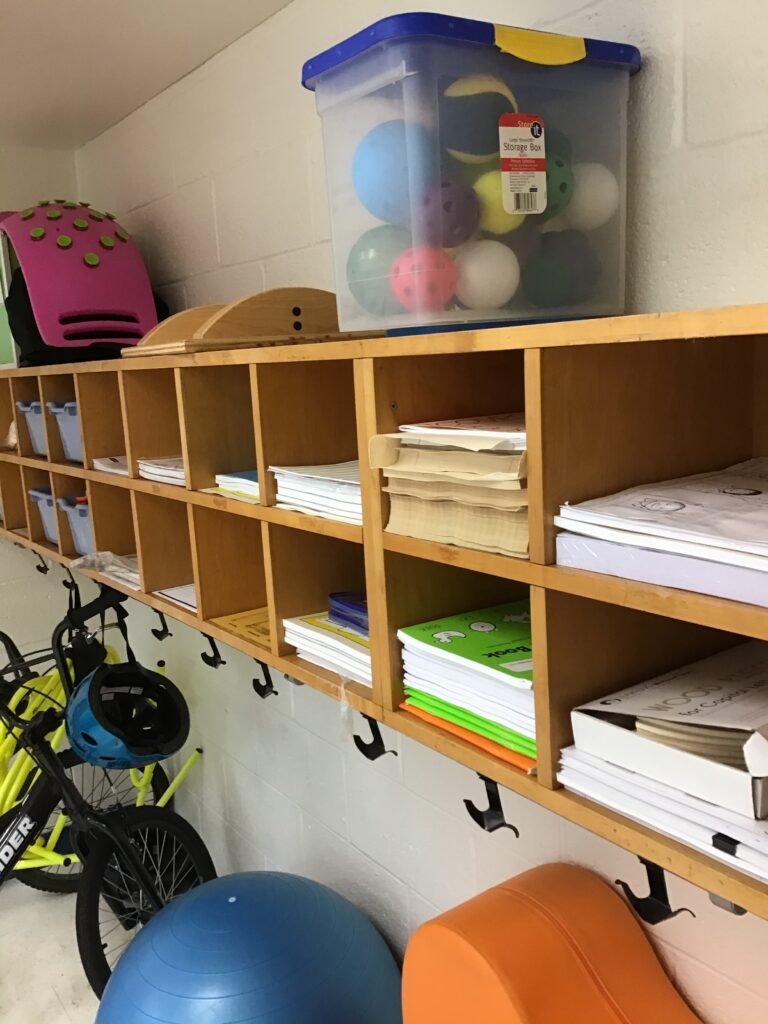 a closer few of the cubbies containing assessments, adapted paper and Handwriting Without Tears workbooks