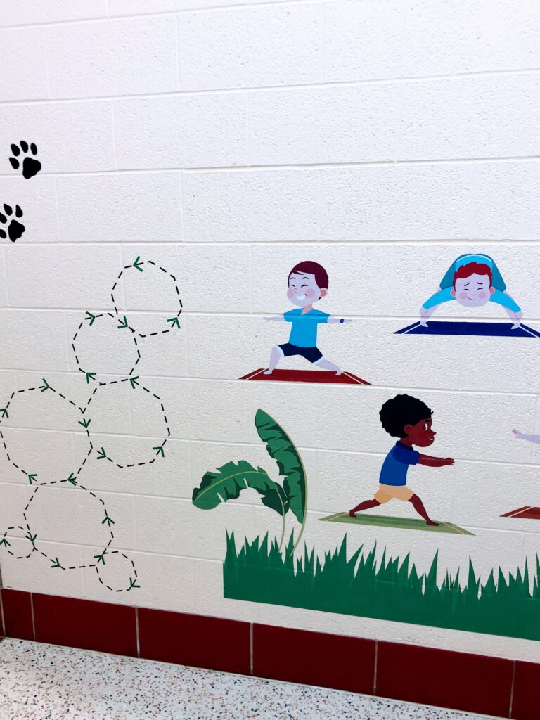 picture of a sample sensory path wall with octagon tracing/breathing shapes and models of yoga poses