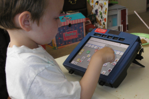 This is an image of a boy using an AAC device