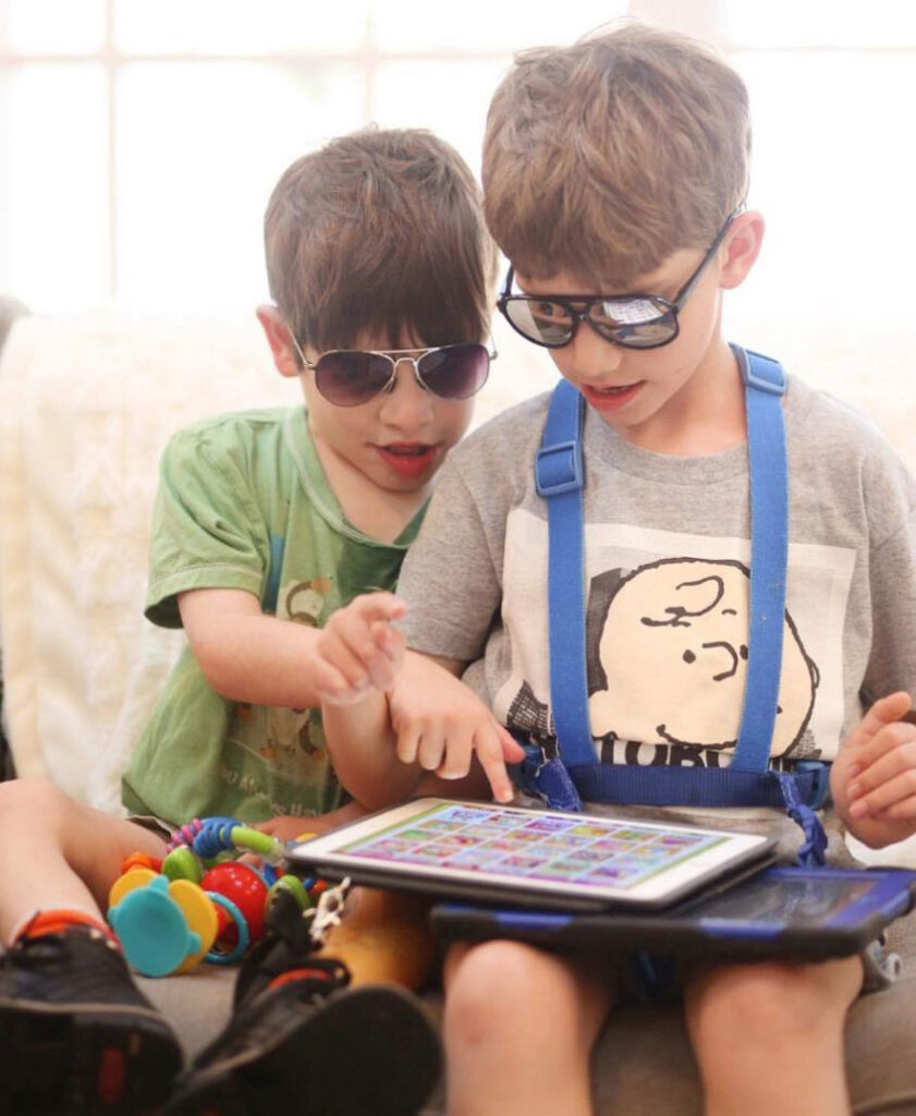 This is an image of two brothers using an AAC device
