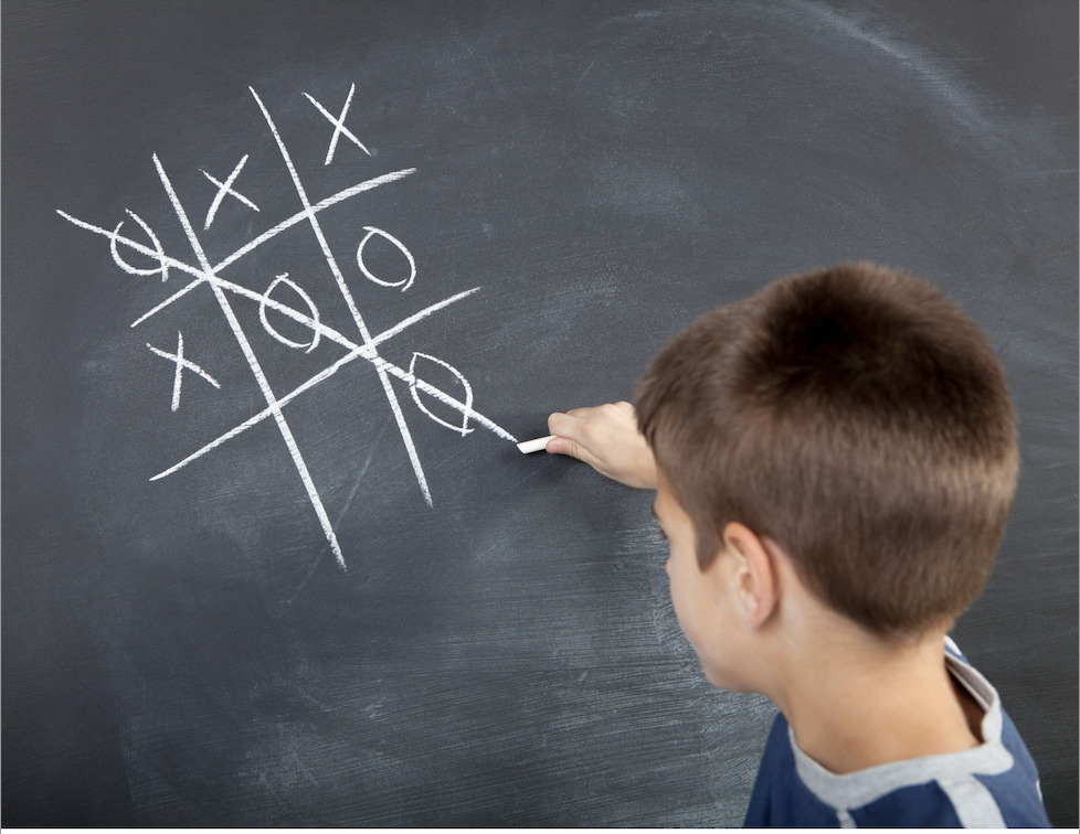 student playing tic tac toe on the chalkboard