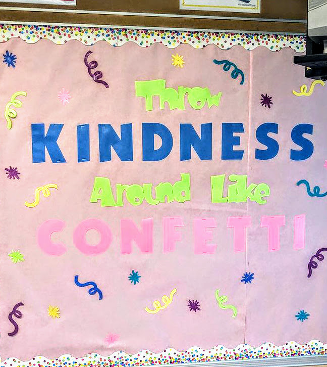 bulletin board with confetti boarder and pieces throughout that reads "throw kindness around like confetti"