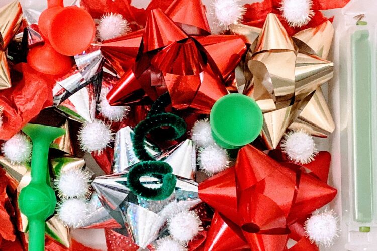 sensory bin with red/green/gold/white bows, tissue paper, squids, pipe cleaners, pom poms, etc.