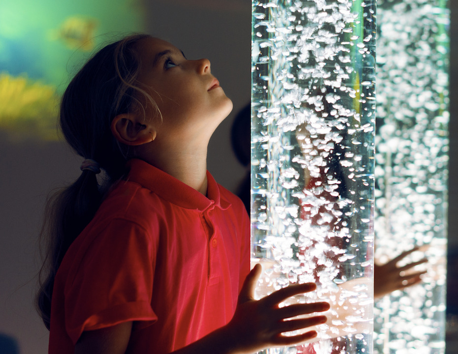 a student looking at a bubble tube as a visual sensory activity
