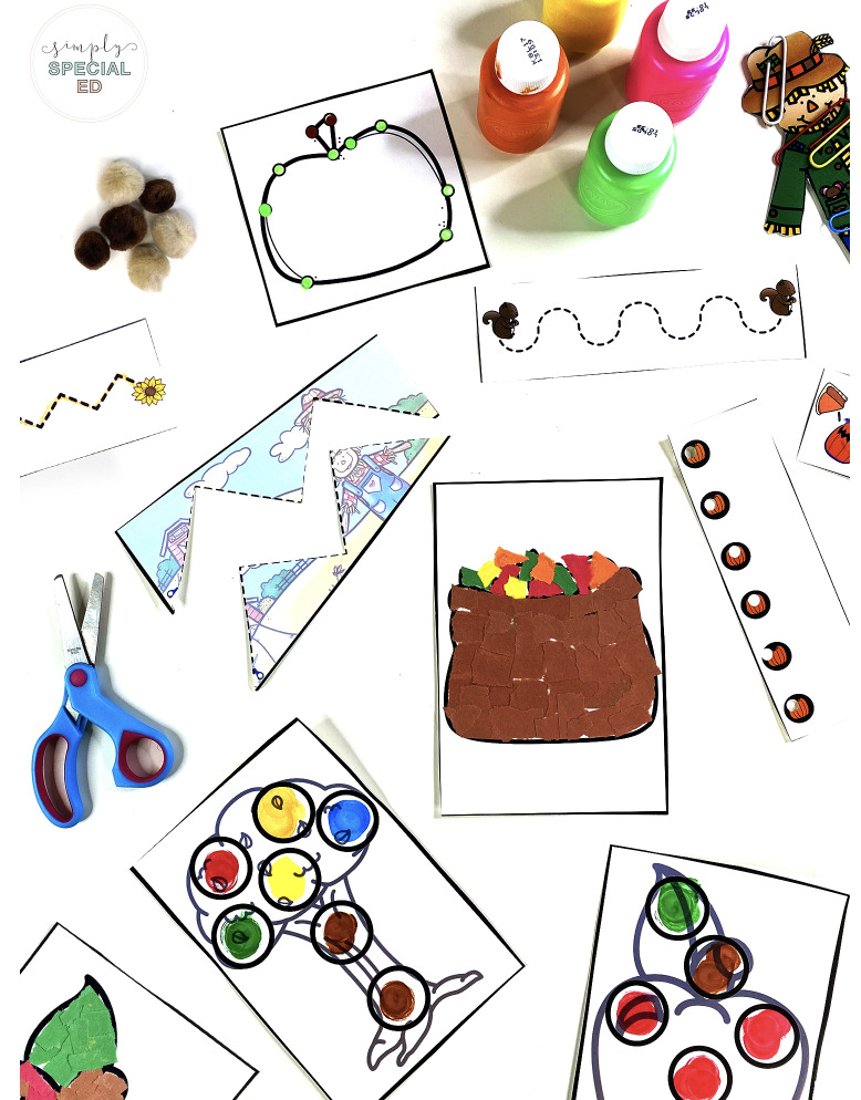 a variety of the fall fine motor center materials spread out on the table such as the poke it q tip paining, cut it center, tear it, trace and punch it. 