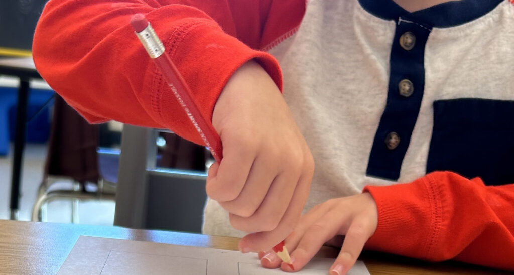 student uses an immature pronated pencil grasp with no forearm stabilization and all fingers wrapped around the pencil to draw on paper