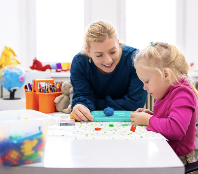 school based occupational therapist working with a young girl using play dough