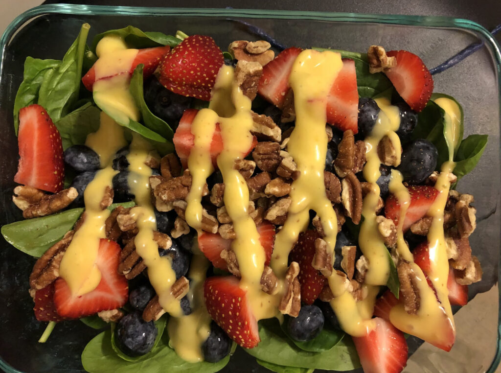 spinach salad with blueberries, strawberries, pecans and dressing