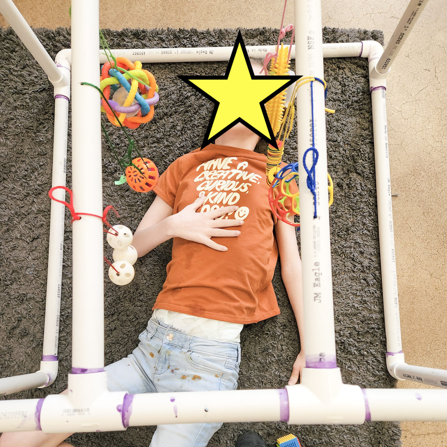 student laying in pvc "little room"