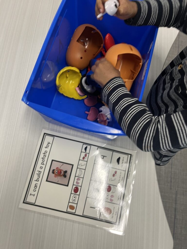 A student using the visual to build a potato head.