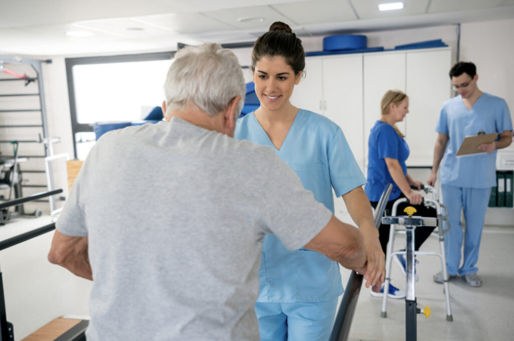 occupational therapist and fieldwork student working with elderly clients in a rehab gym using walkers