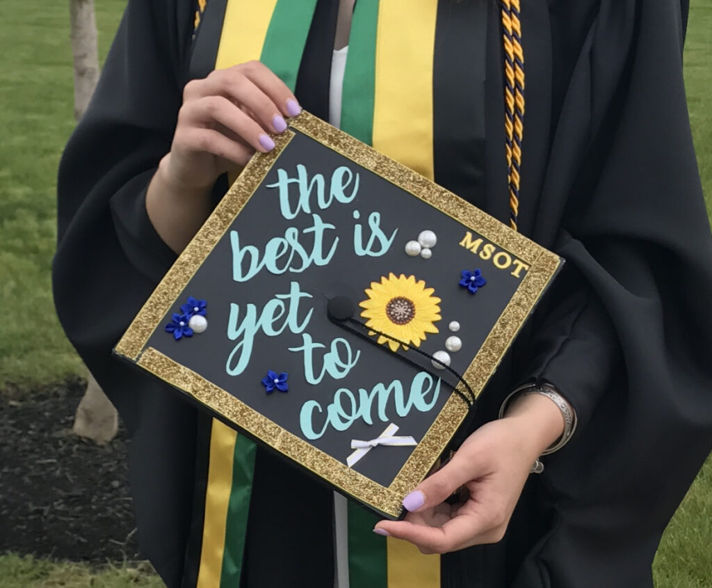 the author's graduation cap reading "the best is yet to come" and "MSOT" at her graduation from occupational therapy school