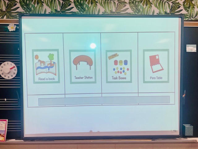 White interactive board displaying Google slideshow of students'' centers