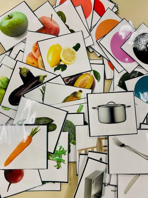 White cards with real photographs on them, including fruits, vegetables, and household items