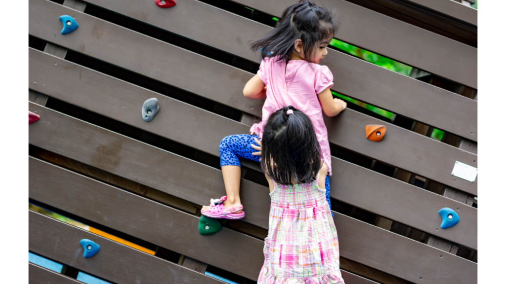 Kids helping each other on the playground.