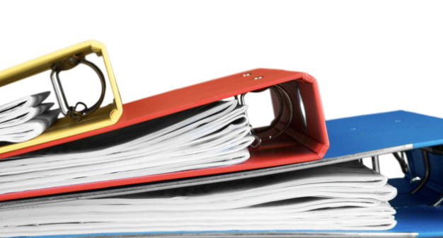 yellow, red and blue three ring binders stacked