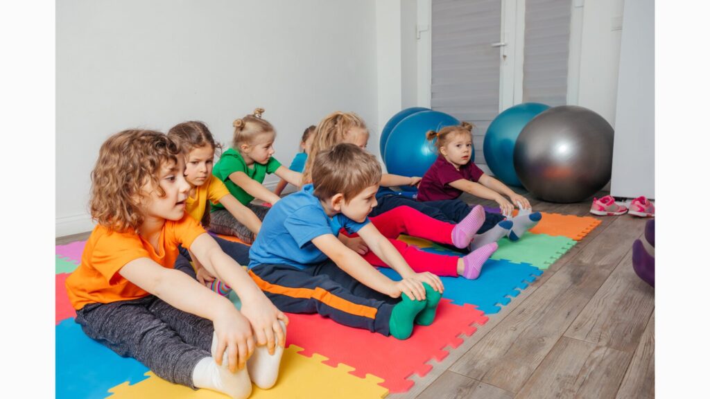 Image of 7 children in a seated fold position, engaging in movement break.