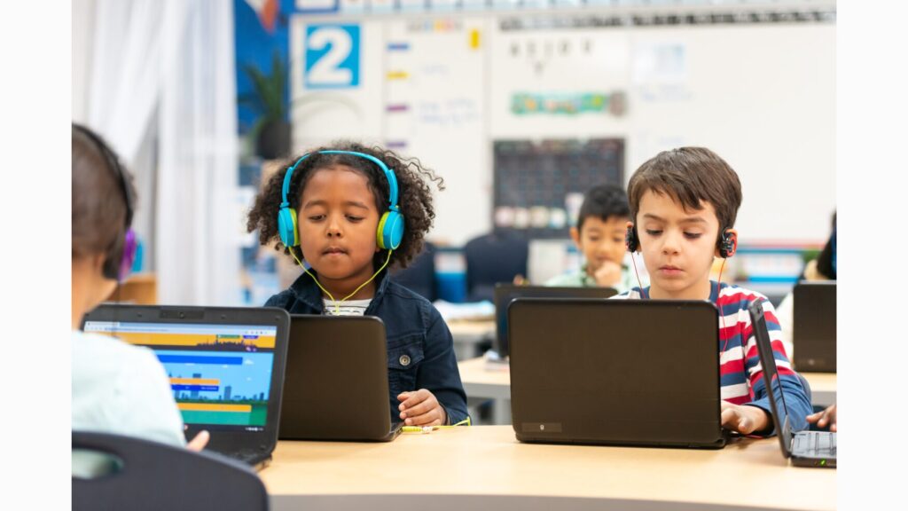 Imgage featuring two three students using technology to supplement their learning.