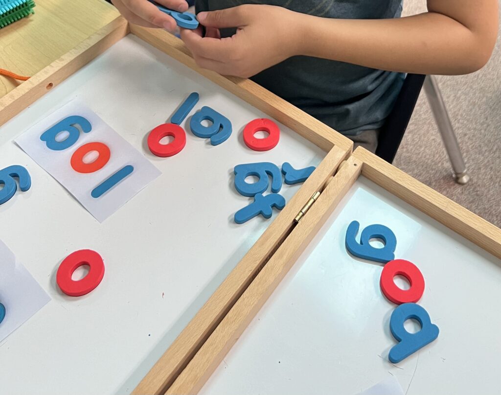 Student using magnet letters to spell high frequency words during center rotations 

