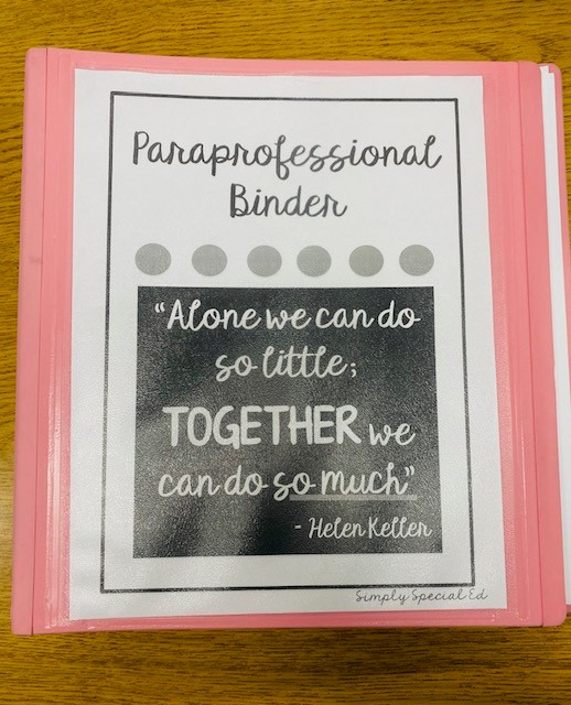 A pink binder is shown on a table. The binder has a label that says "Paraprofessional Binder."